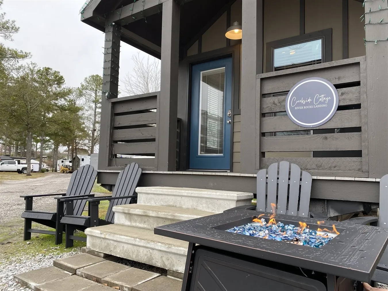 A porch with a fire pit and Adirondack chairs