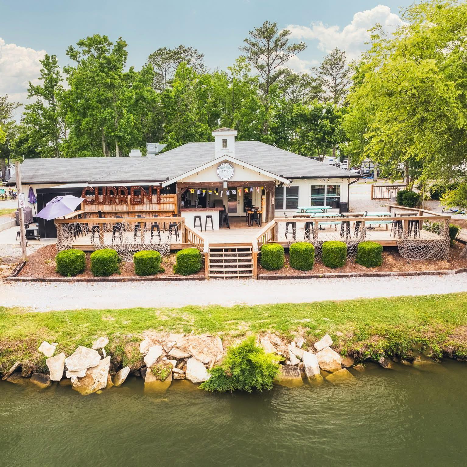 A waterfront restaurant with a large deck and seating area.